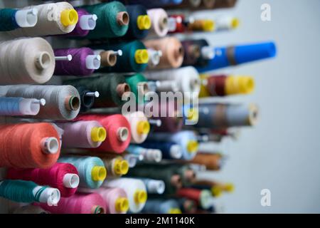 Collection of multi-colored spools of thread on special holders Stock Photo