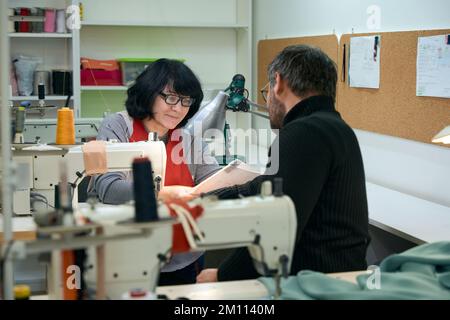 Tailors, a man and a woman, are considering working sketches Stock Photo