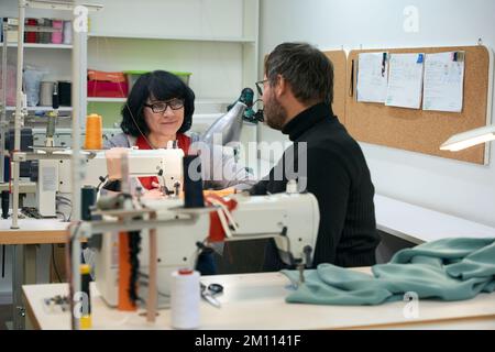 Fashion designers, a man and woman, communicate in working environment Stock Photo