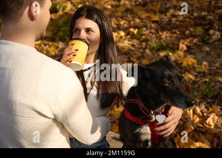 Beautiful young woman is drinking coffee and chatting with her boyfriend Stock Photo