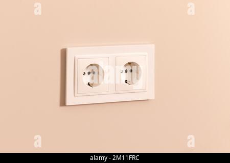 Group of white european electrical outlets on modern beige wall Stock Photo