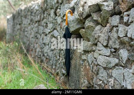 Umbrella over dry stone fence on a cloudy autumn day Stock Photo