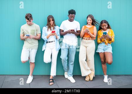 Group multiracial friends using smartphones outside Stock Photo