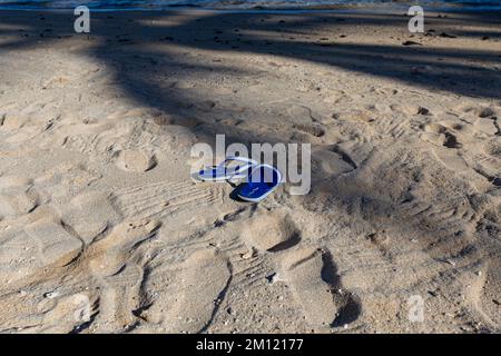 Flip flops or sandals for woman on sand beach at coast with effect light sun set on sea. tourism relax travel tropical summer in holidays or broken heart concept. free space image. Stock Photo