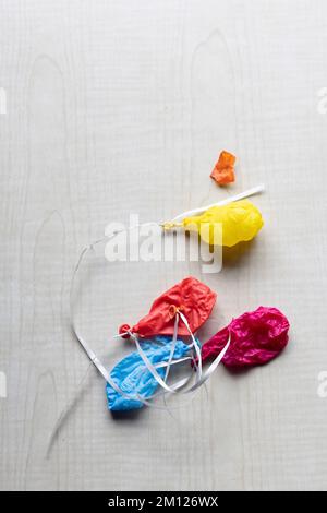 Shriveled colorful balloons on a white ribbon Stock Photo