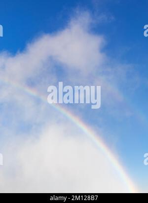 Rainbow against a blue sky and clouds Stock Photo