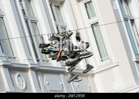 Shoes hanging on a line in Norderstraße, Flensburg, Schleswig-Holstein, Germany Stock Photo