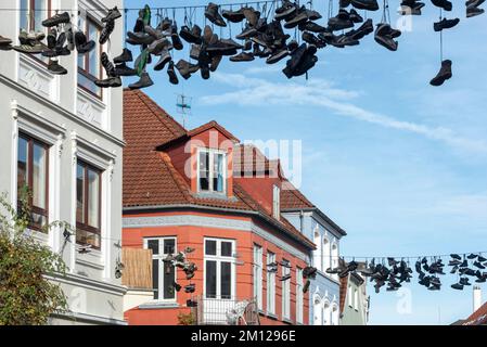 Shoes hanging on a line in Norderstraße, Flensburg, Schleswig-Holstein, Germany Stock Photo