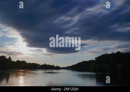 View over Griebnitzsee lake in Potsdam to sunset, rower in foreground Stock Photo