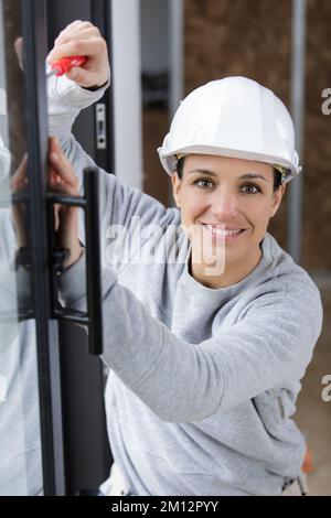 female worker fixing the window with screwdriver Stock Photo