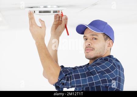 contractor taking ceiling measures with pencil Stock Photo