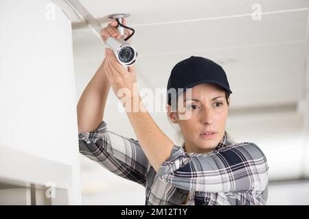 pretty concentrated female cctv installing cctv Stock Photo
