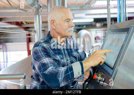 senior operating machine in factory Stock Photo