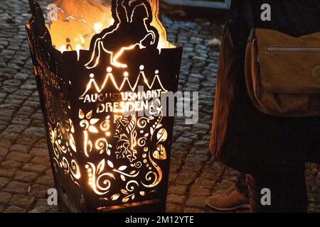 Dresdner Christmasmarkets in Winter 2022, illuminated during the night. A detailed photo of a fire barrel with an inscription. Stock Photo