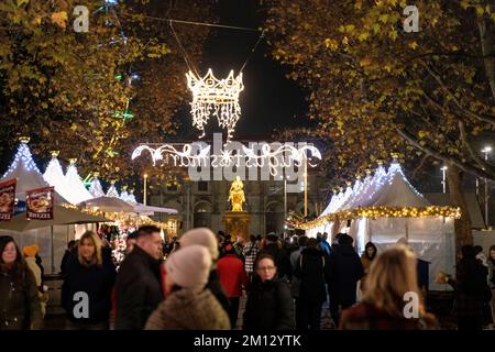 Dresdner Christmasmarkets in Winter 2022, illuminated during the night. In the background the statute of the Goldener Reiter at the Augustusmarket. Stock Photo