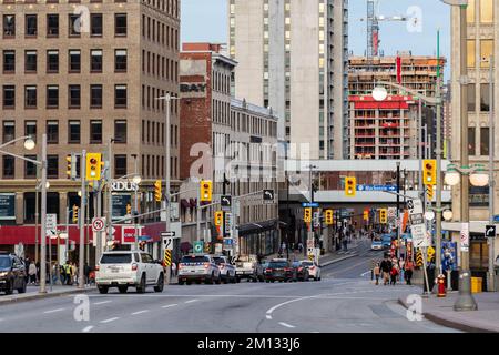 Ottawa, Canada - November 5, 2022: Busy Rideau street in downtown district. Cityscape with intersection, traffic lights, and walking people. Stock Photo