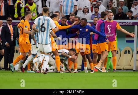 Argentina's Leandro Paredes on floor is surrounded by players after kicking the ball at the Netherlands bench during the FIFA World Cup Quarter-Final match at the Lusail Stadium in Lusail, Qatar. Picture date: Friday December 9, 2022. Stock Photo