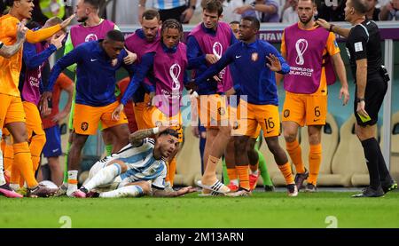 Argentina's Leandro Paredes on floor is surrounded by players after kicking the ball at the Netherlands bench during the FIFA World Cup Quarter-Final match at the Lusail Stadium in Lusail, Qatar. Picture date: Friday December 9, 2022. Stock Photo