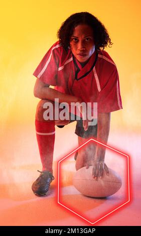 Composite of biracial female rugby player with ball bending by illuminated red hexagon Stock Photo