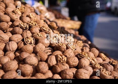 Natural Walnuts with shell background pattern texture. Background of fresh walnuts in shell. Lots of Walnuts with shell at the market in Istanbul Stock Photo