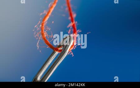 Thread in the eye of a needle Stock Photo
