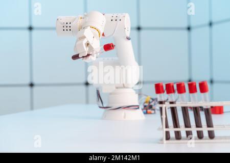 Robotic arm holding blood sample Stock Photo