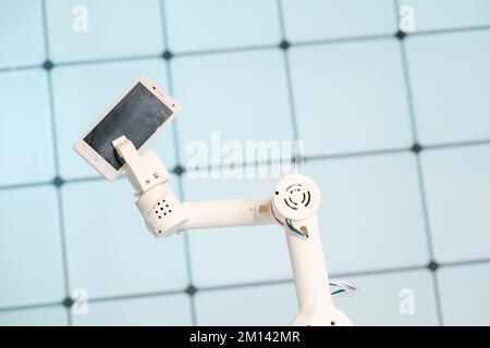 Robotic arm holding mobile phone Stock Photo