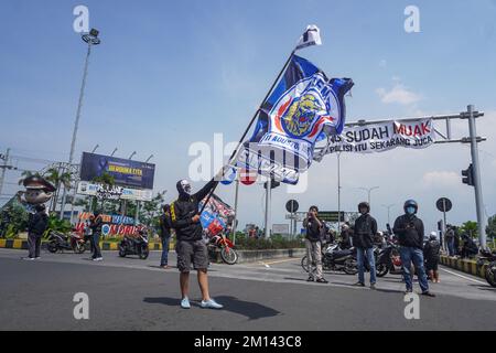 Malang, Indonesia. 08th Dec, 2022. A demonstrator carries a flag with the Crazy Lion logo of the soccer team Arema FC, during the protest. Aremania, the supporters of Arema FC, held a rally and blocked streets in some spots in Malang to protest the legal process of the soccer stampede tragedy, which killed 135 people due to the police tear gas at Kanjuruhan Stadium on October 1, 2022. (Photo by Dicky Bisinglasi/SOPA Images/Sipa USA) Credit: Sipa USA/Alamy Live News Stock Photo