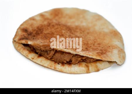 Shami Syrian pita bread with mashed fava beans mixed with oil, sesame tahini, cumin, spices, selective focus of traditional popular Egyptian bean sand Stock Photo