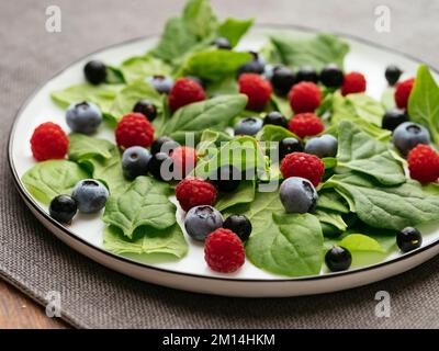 Healthy salad with fresh New Zealand spinach, blueberries, raspberries and blackcurrants Stock Photo