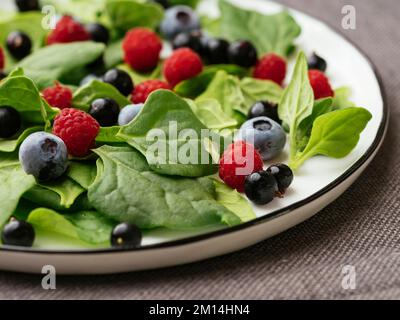 Healthy salad with fresh New Zealand spinach, blueberries, raspberries and blackcurrants Stock Photo