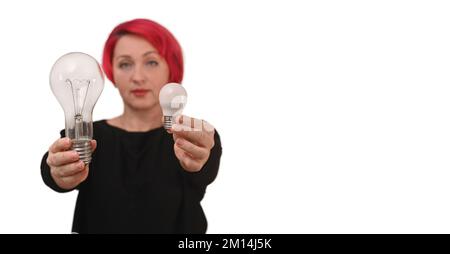 Girl hold energy saving led bulb and incandescent lamp. Energy efficiency concept. Isolated on a white background. Stock Photo