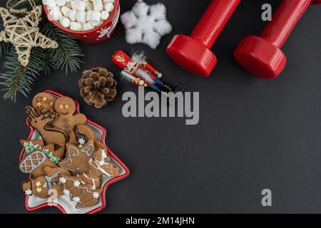 Homemade gingerbread Christmas cookies, gym workout dumbbells, hot chocolate cocoa with marshmallows. Fitness winter diet, flat lay with copy space. Stock Photo