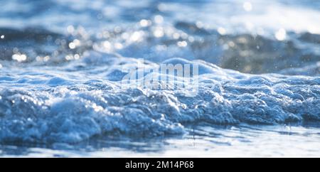 Abstract background of sea waves and blue water with blur bokeh bright lights. Stock Photo