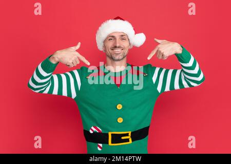 happy new year. merry christmas.pointing finger on himself. happy man in elf costume. Stock Photo