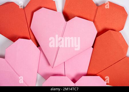 Origami for Valentine's Day - hearts made of paper on a white background do it yourself. Stock Photo
