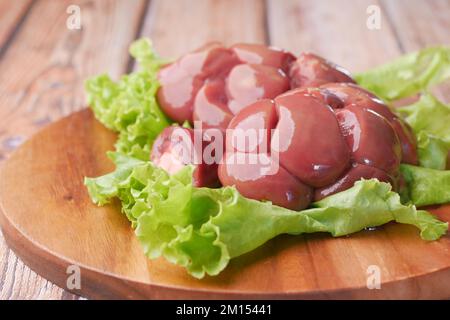 Raw fresh lamb kidneys on a chopping board  Stock Photo