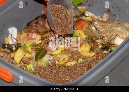 Bokashi fermenting and composting method. Composting in kitchen with EM Effective Microorganisms which are impregnated on the wheat bran to ferment fo Stock Photo