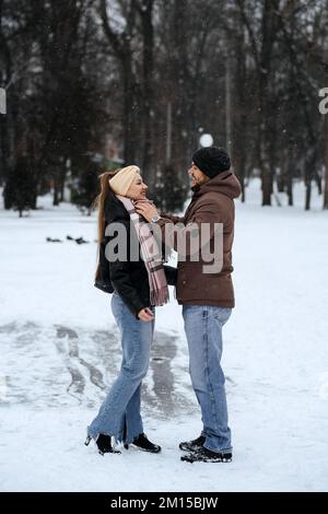 Winter couple activities. Winter Date Ideas to Cozy Up. Cold season dates for couples. Young couple in love waking, skating and having fun in winter Stock Photo