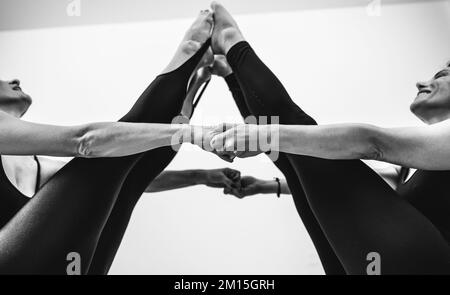 Fit mature women couple doing acro yoga. Yoga, balance and mindful relaxation concept. Stock Photo