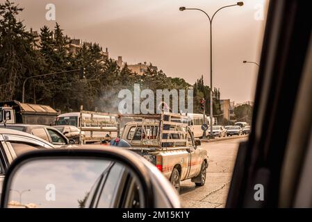 Amman, Jordan - Thursday, February 06 2018 girl in pick up truck car traffic at sunset in amman streets, view from inside the car Stock Photo