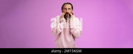 Impressed surprised handsome adult bearded man grey hair attend barber shop cannot believe see own reflection become stylish cool-looking touching Stock Photo