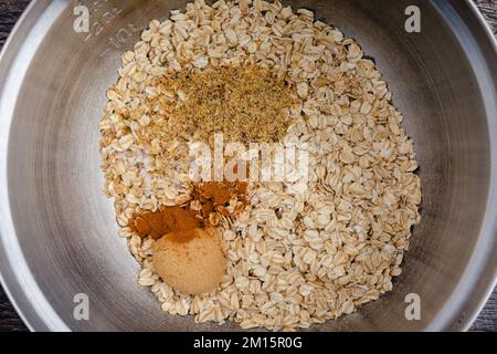 Dry Ingredients for Baked Oatmeal in a Mixing Bowl Closeup: Rolled oats, ground flaxseed, cinnamon, brown sugar, and salt in a large bowl Stock Photo
