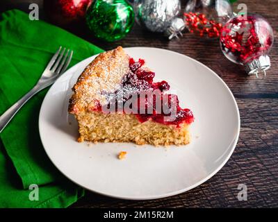 Sliced Piece of Spiced Mascarpone Cranberry Cake on a Plate: Single layer cake spiced with cinnamon and nutmeg topped with cranberry sauce Stock Photo