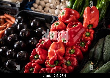 From above of ripe bell peppers cucumbers carrots and mushrooms placed on stall in local market Stock Photo