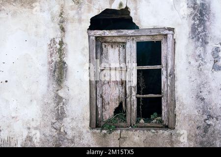Window with damaged shutters outside abandoned aged house on Way of St James in Galicia, Spain Stock Photo