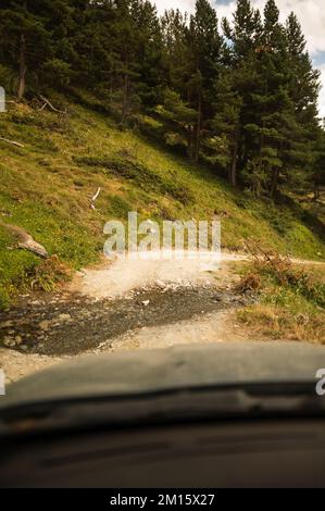 View through window of car on narrow roadway during sundown in Pyrenees Stock Photo