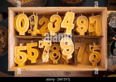 Top view of various colorful candles in form of numbers placed in wooden box on store shelf Stock Photo