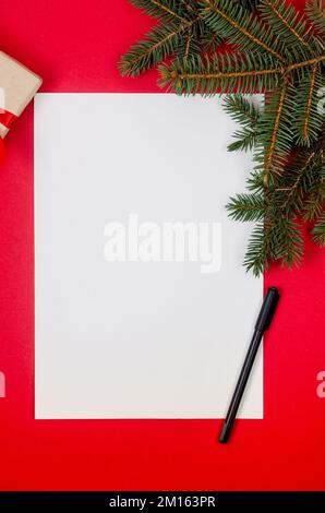 Letter to Santa Claus. Christmas and New Year holiday card with empty paper sheet on red background. Christmas decorations and white paper with place Stock Photo