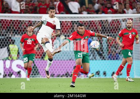 Doha, Qatar. 10th Dec, 2022. Joao Cancelo (2nd L) of Portugal vies with Walid Cheddira of Morocco during their Quarterfinal of the 2022 FIFA World Cup at Al Thumama Stadium in Doha, Qatar, Dec. 10, 2022. Credit: Lan Hongguang/Xinhua/Alamy Live News Stock Photo